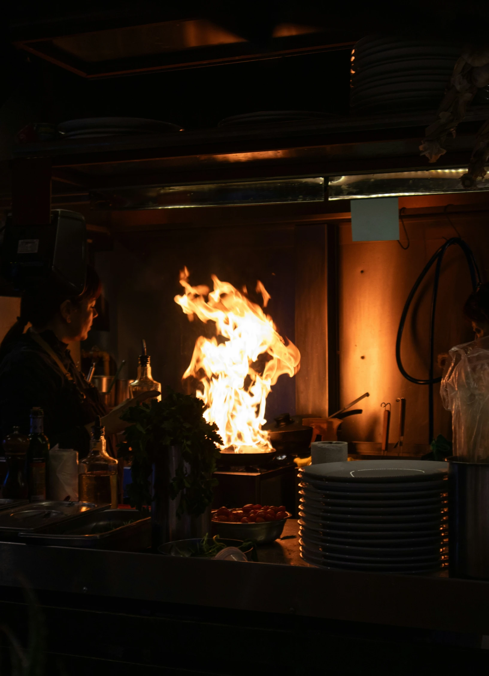 a woman in a kitchen on fire with lots of dishes and utensils