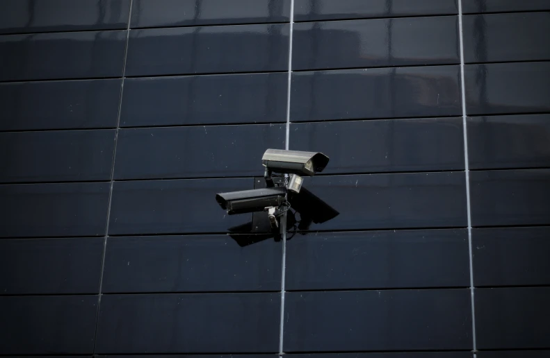 several cameras mounted on a black wall