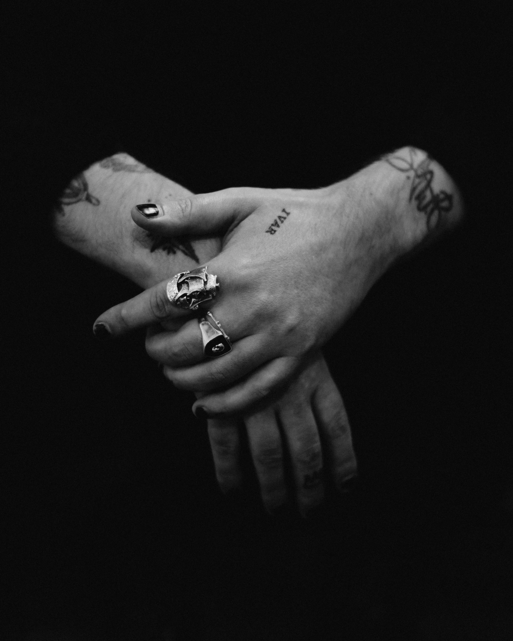 two people holding hands with tattoos on their arms