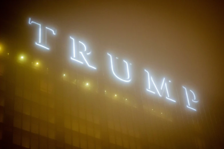 the word trump spelled in neon on a dark night