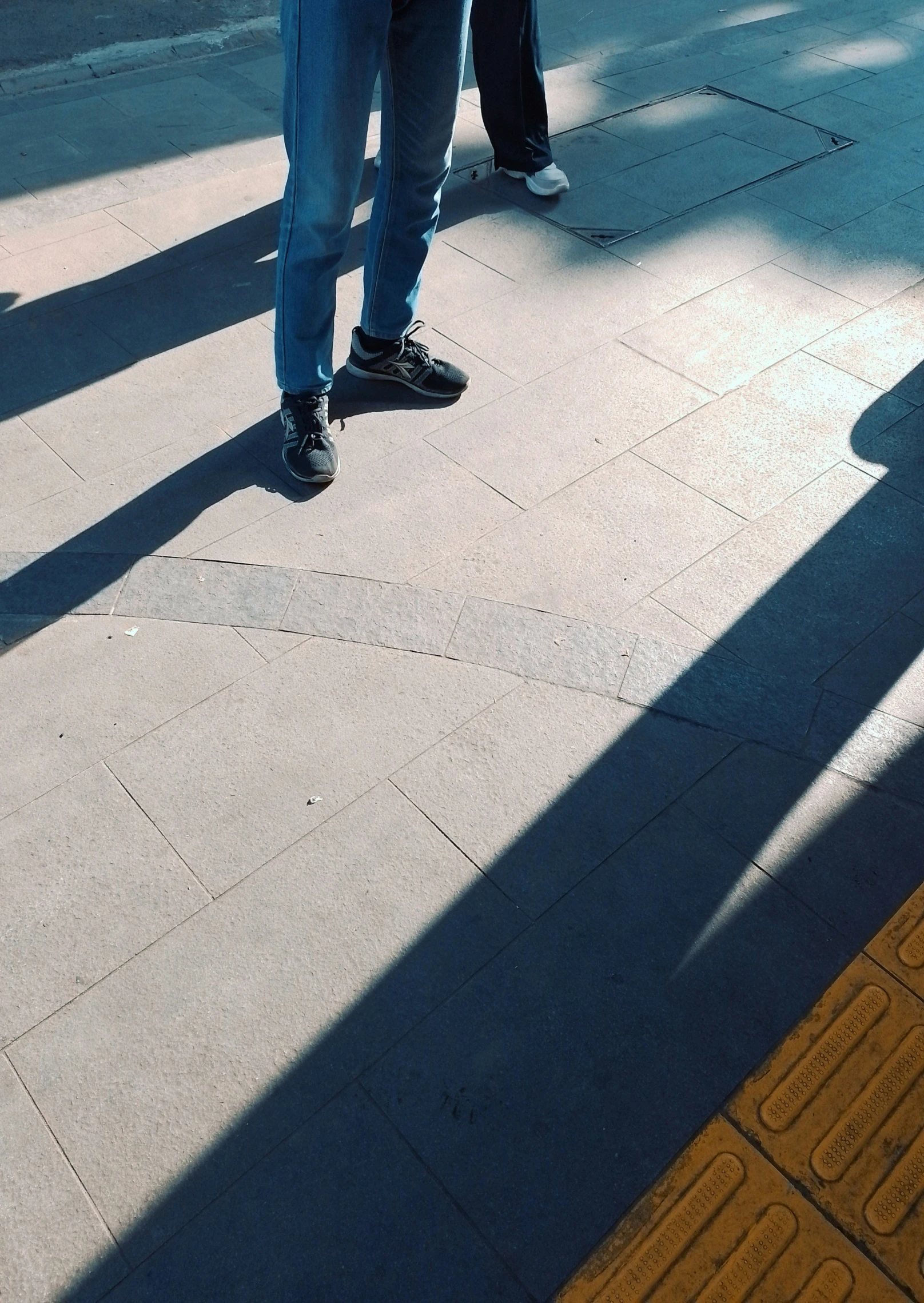 two people are standing on a city sidewalk