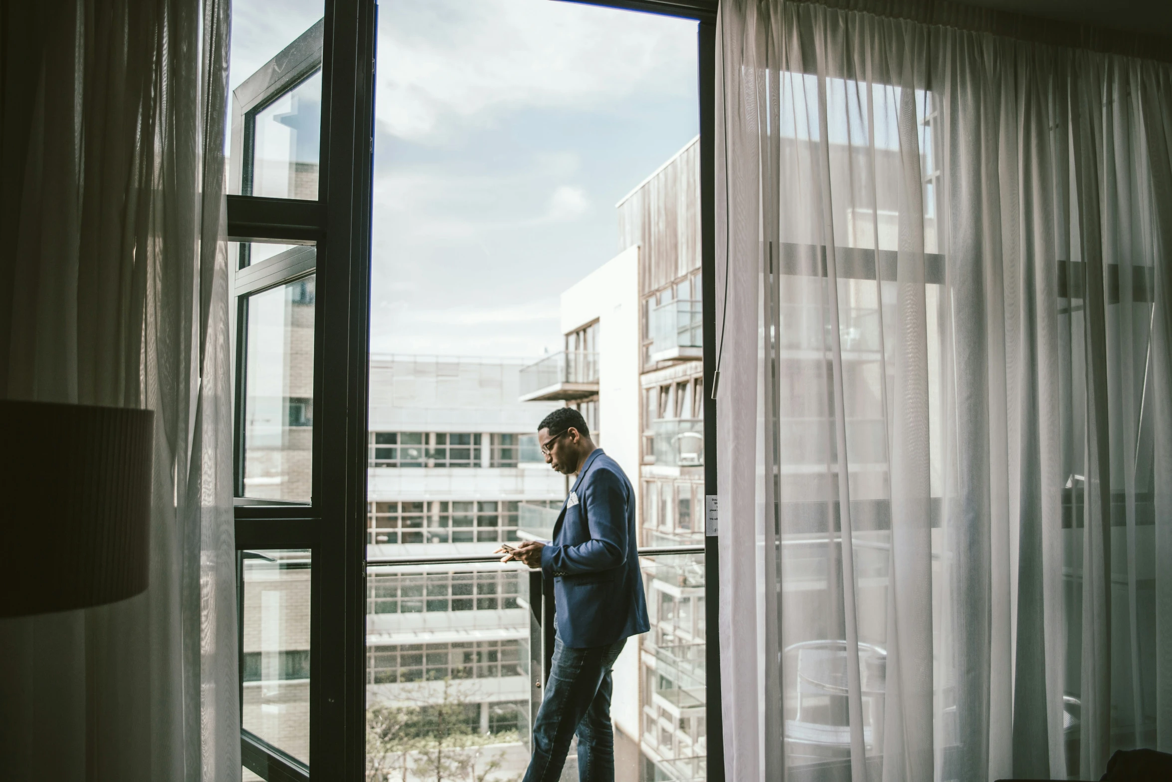 a man standing in an open door while using his cellphone