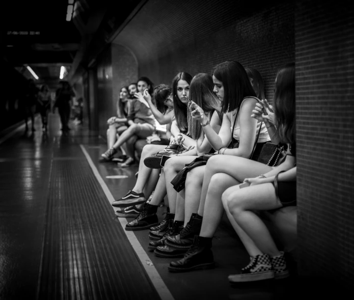 there are many women sitting on the subway platform