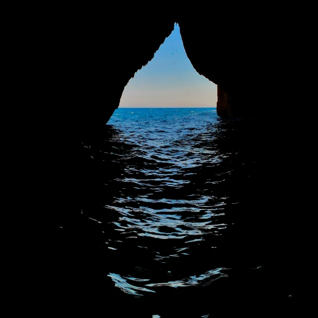 a large rock formation in the middle of a body of water