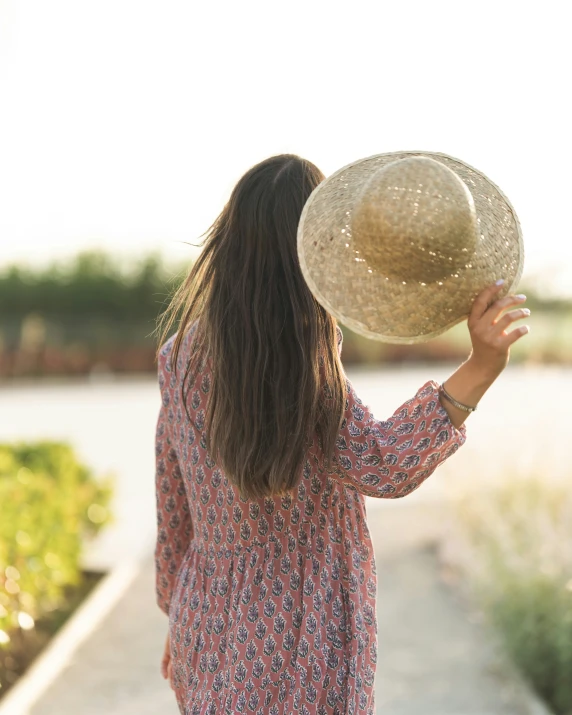 a woman wearing a floppy hat on the beach