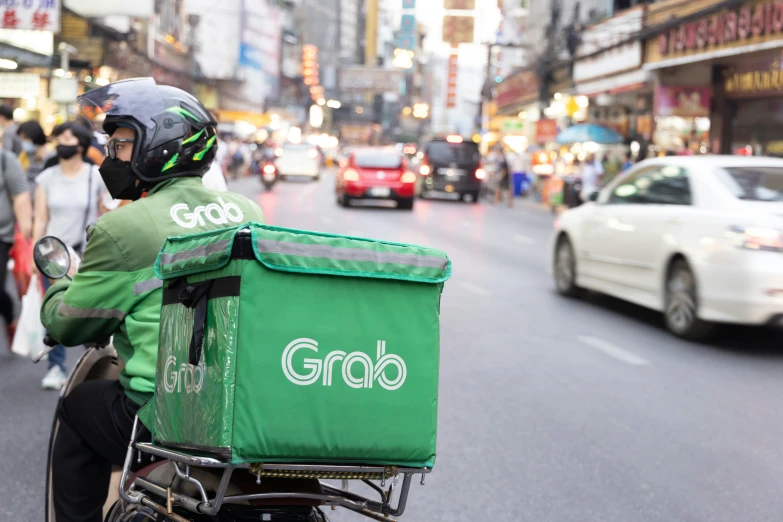 a man is riding down the road with his shopping bag in hand