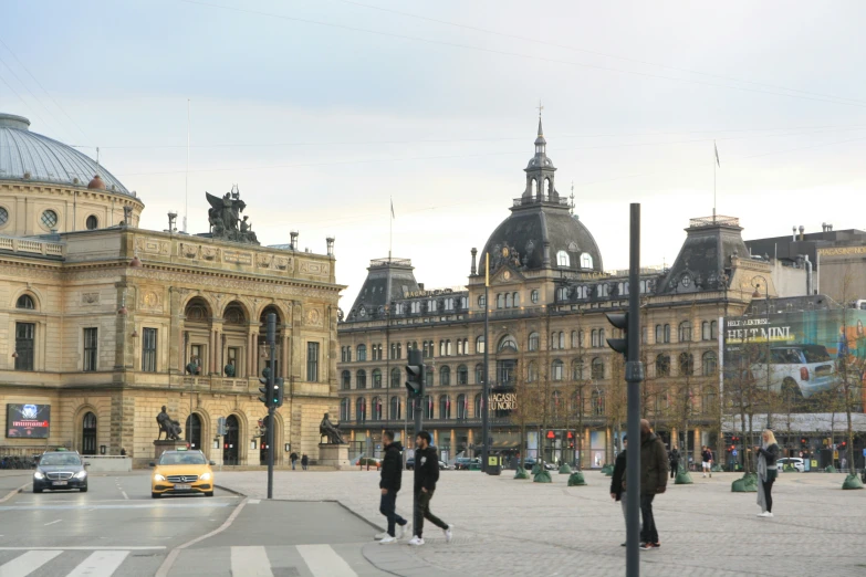 many people are crossing the street in front of buildings