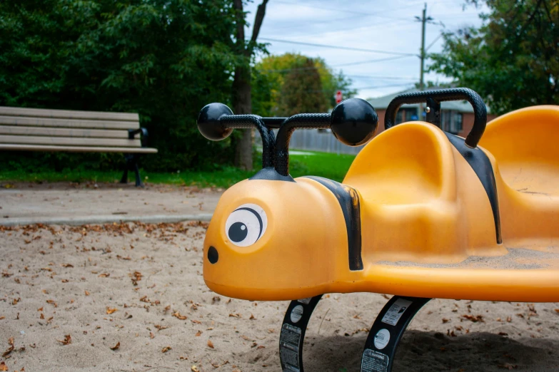 a little bus with eyes is on a playground