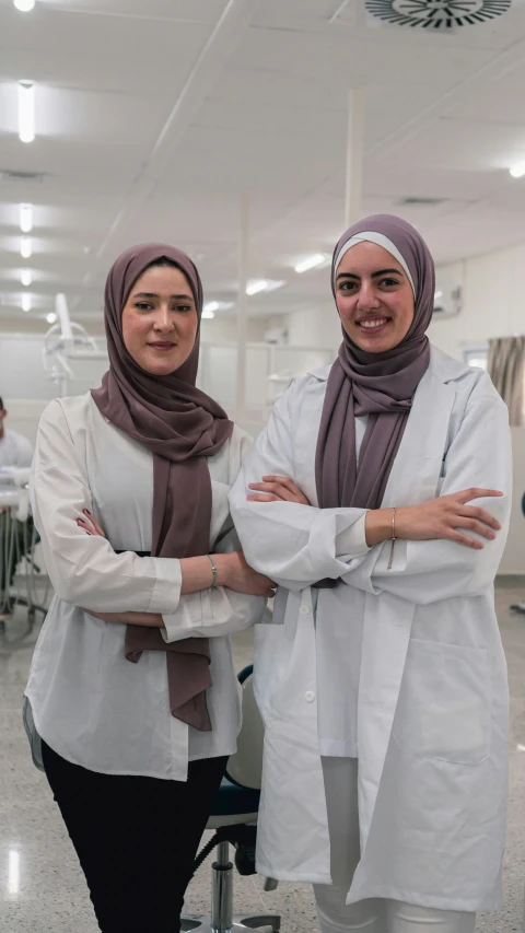 two female dentists with their arms crossed standing