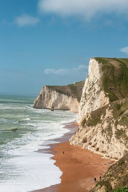 a beach that is near to a very large cliff