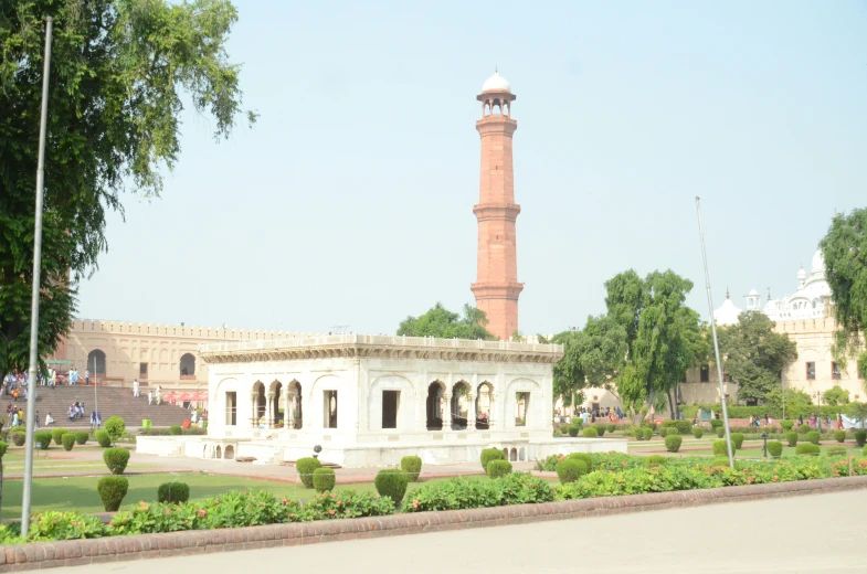 a tower stands tall in the middle of a garden