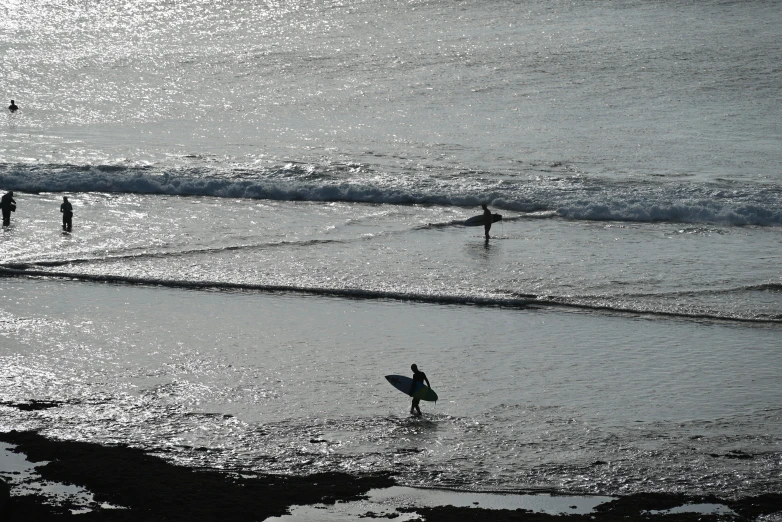 a couple of people walking into the ocean