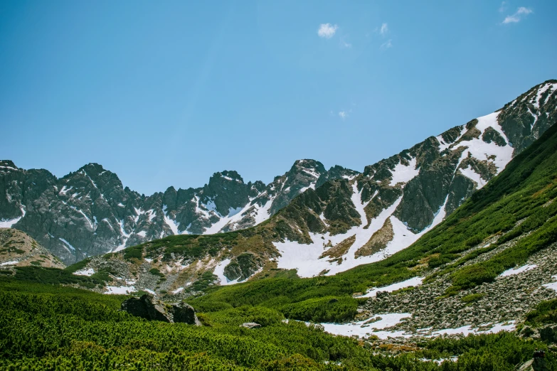 a large mountain range that has a few patches of vegetation