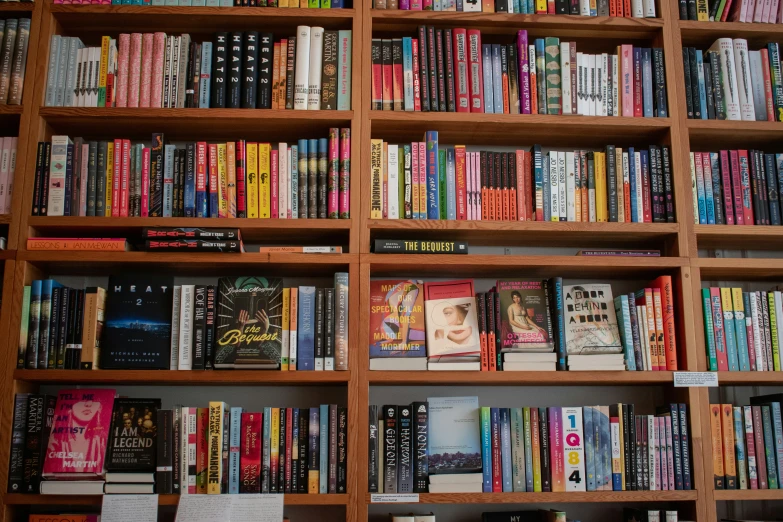 books are arranged in a bookshelf with papers and other items