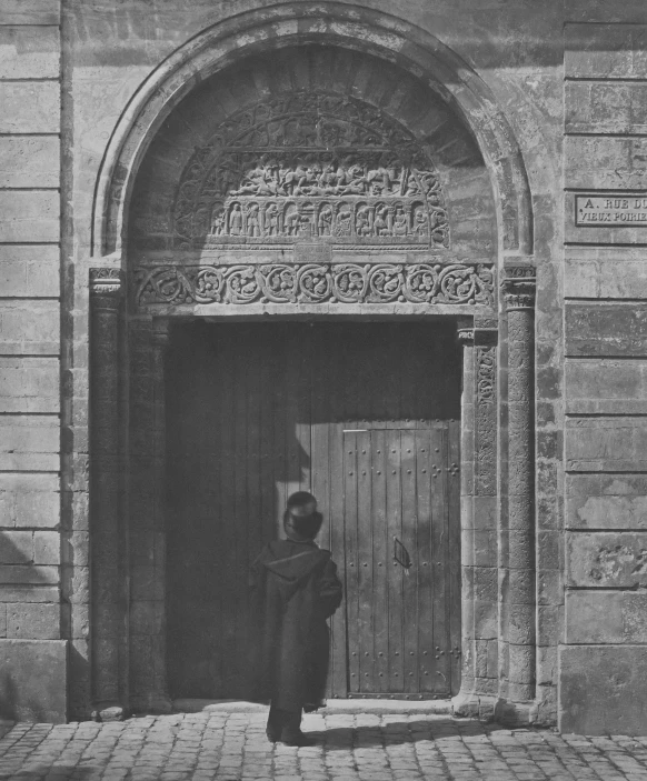 a black and white po of a person near an arched doorway