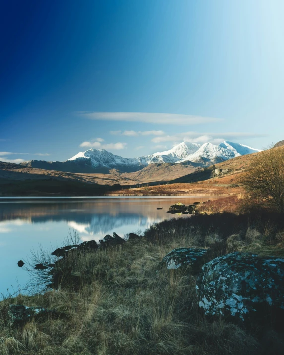 a lake surrounded by mountains in the distance