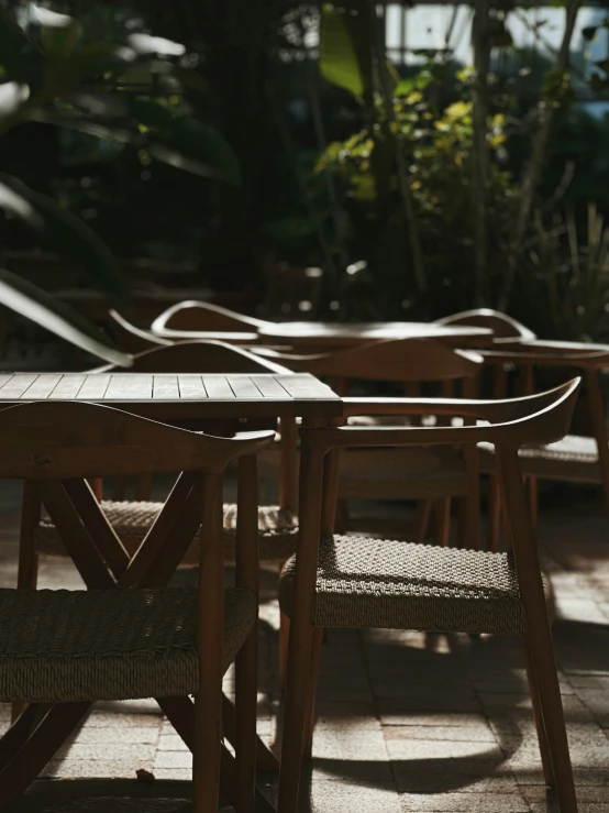 some wooden tables and chairs sitting next to each other