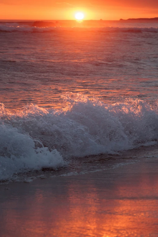 the sun sets over a large body of water