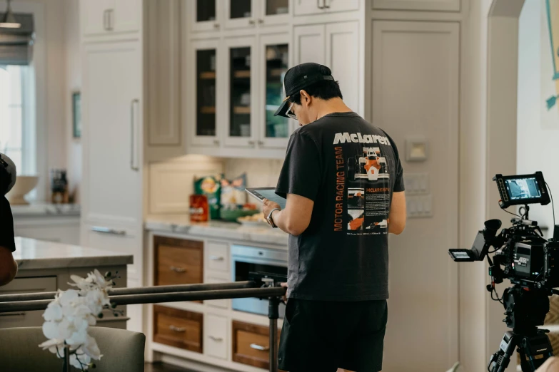 the man is in the kitchen with his cell phone