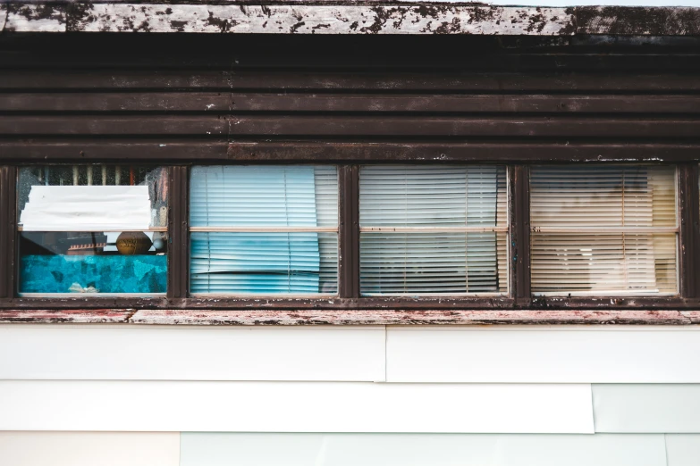 an old window with wood slats and torn curtains