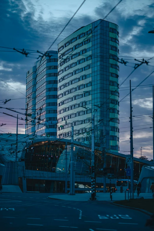 an empty city street and tall building with lights on