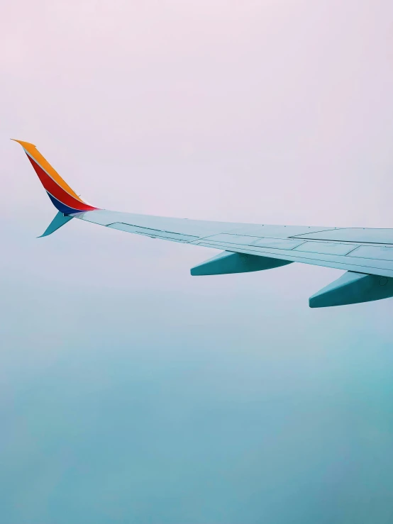 the side of an airplane wing above the water