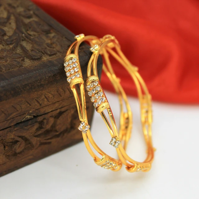 a pair of golden celets with diamond beads