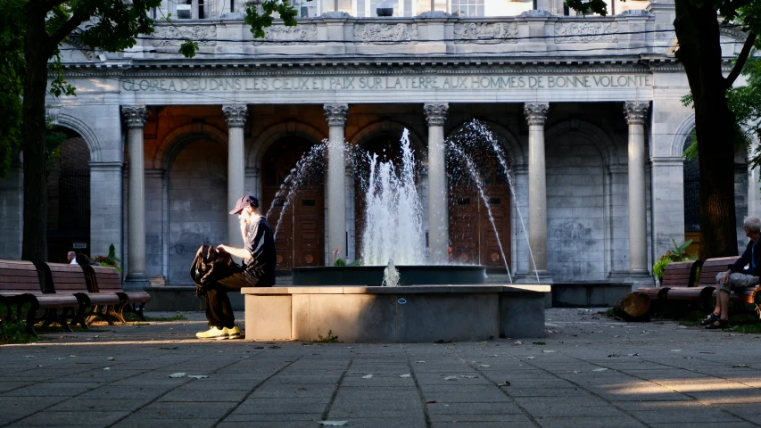 a woman sitting on top of a fountain