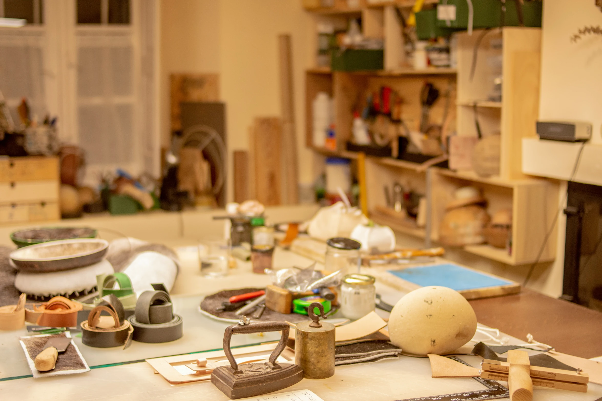 many materials on a table with a cluttered shelf