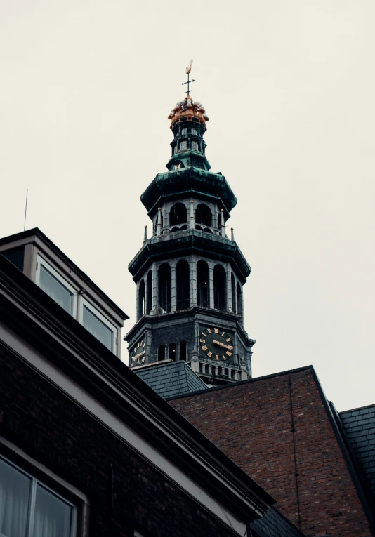 the tall clock tower of a building looks over the buildings