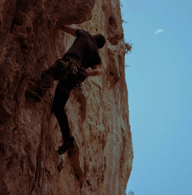 a man climbing up the side of a mountain