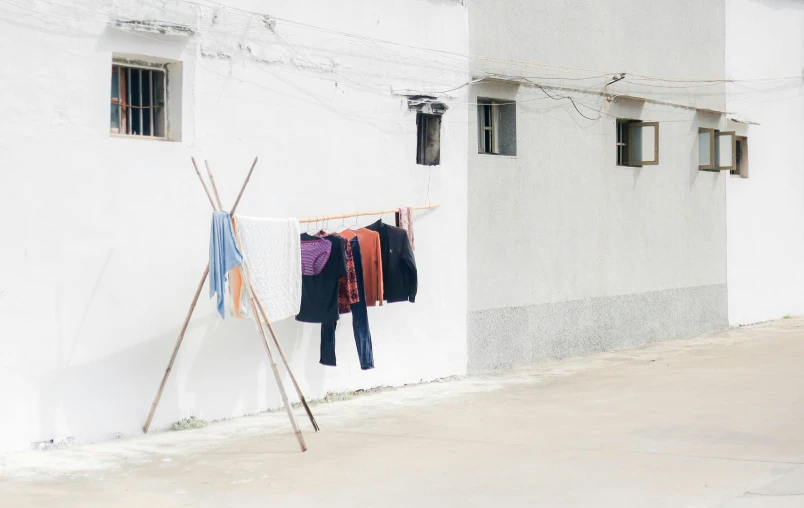 a clothing rack on a street in front of a white building