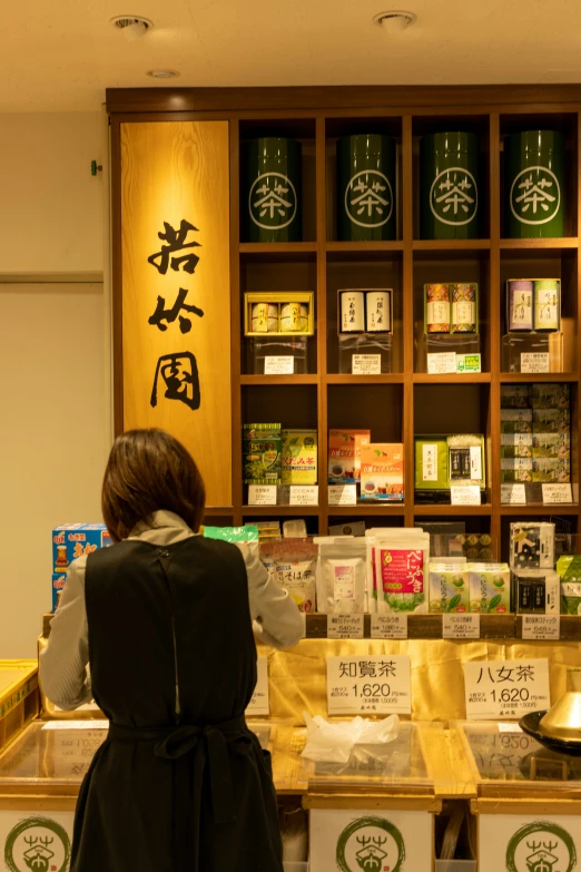 a women behind a counter that has various items on it