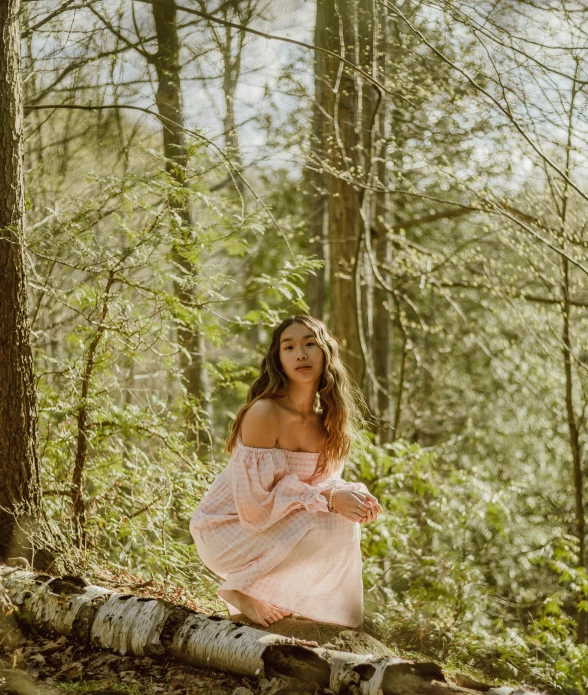 the woman is posing for the camera while sitting on a rock