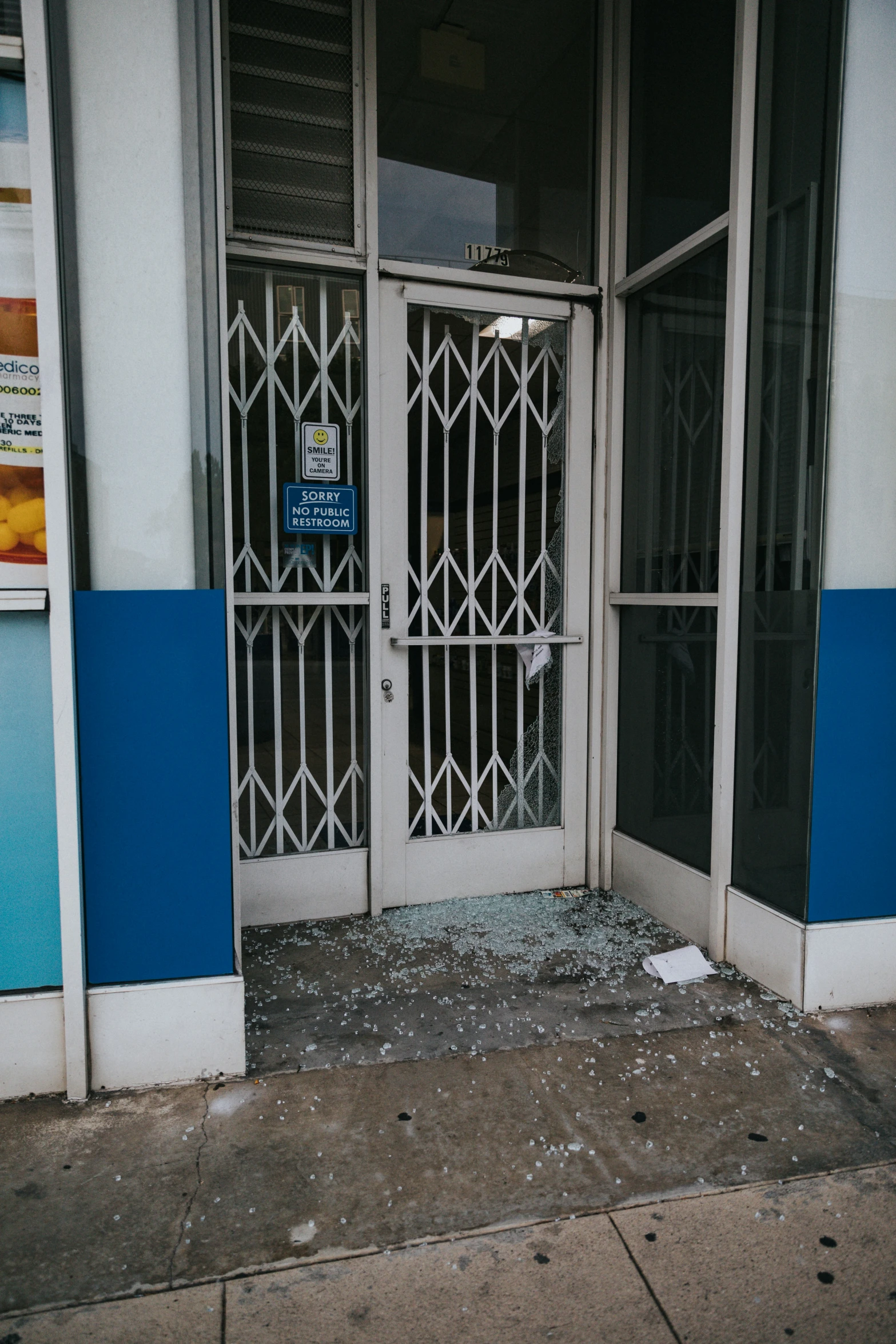 broken window on the side of building with peeling glass