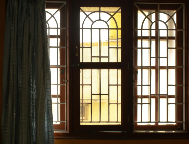 a window with a curtain that has stained glass on top