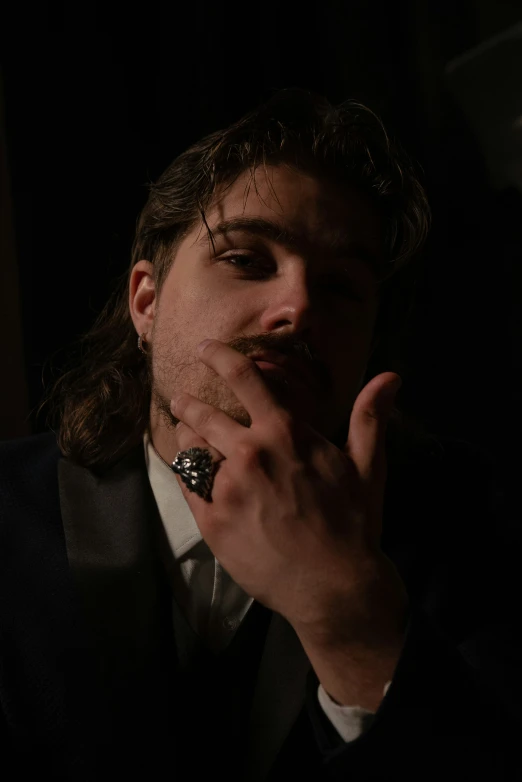 a man with long hair is smoking a cigar