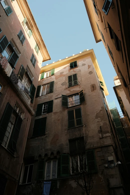 an upward view of several building with windows and shutters