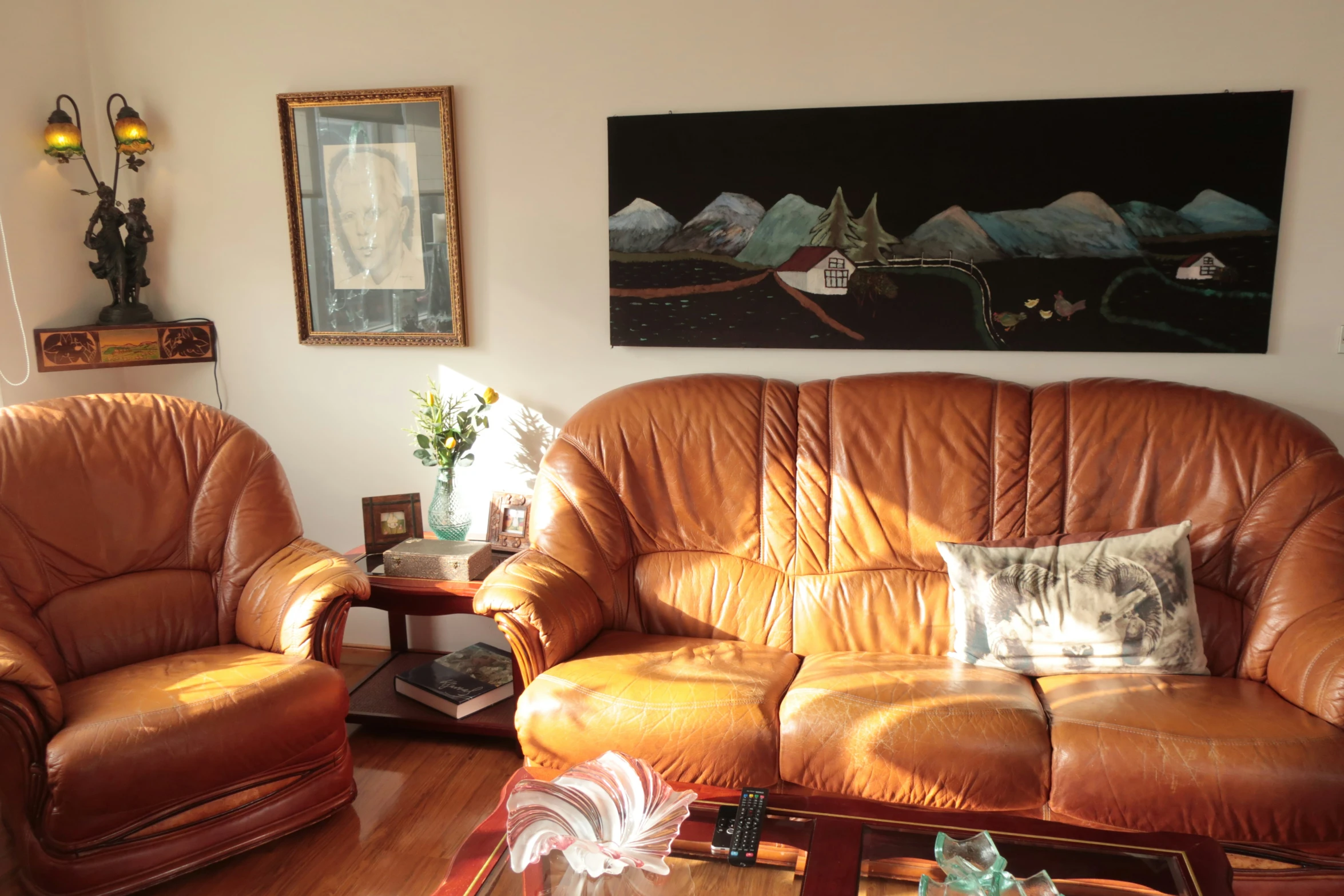 two tan leather couches sitting in a living room