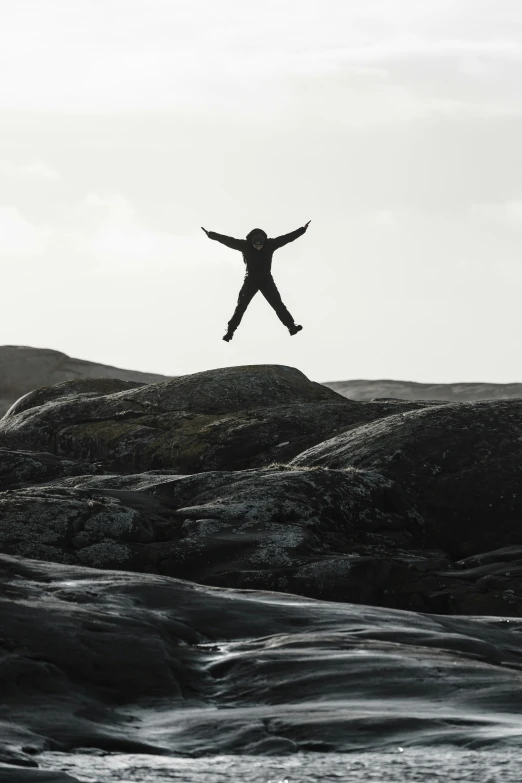 a black and white po of a person on a cliff