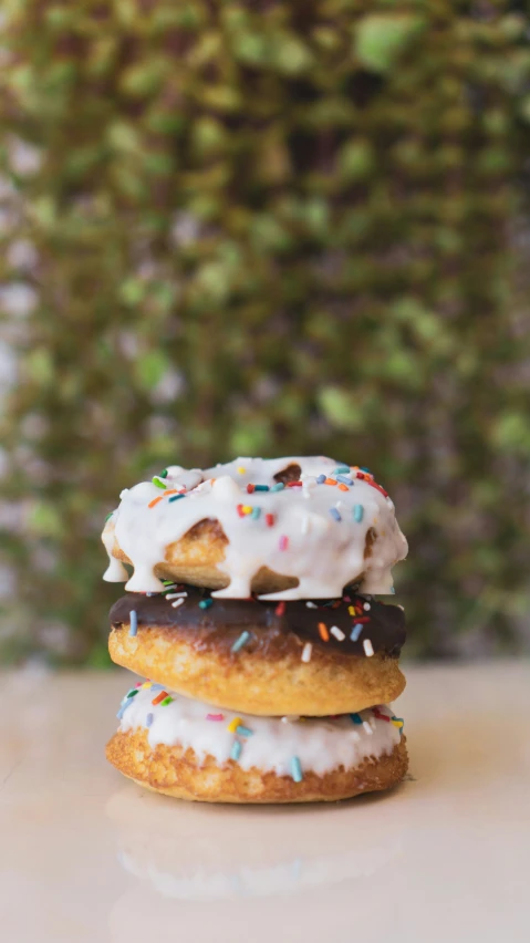 four donuts covered in frosting and sprinkles on a table