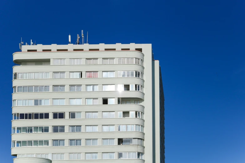 a white building with balconies on top in a city