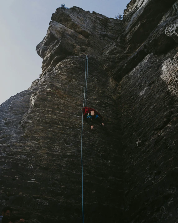 a man climbing a mountain with a rope over his head