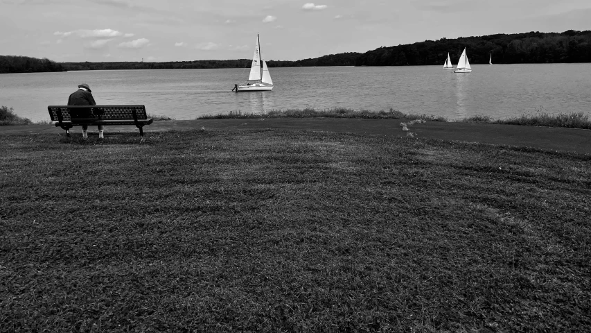 a person sitting on a bench by the water