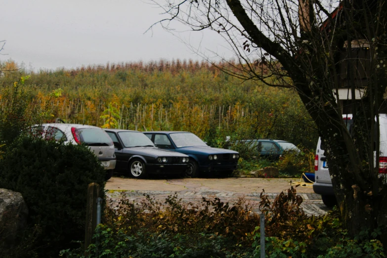 a group of four cars parked in a lot next to each other