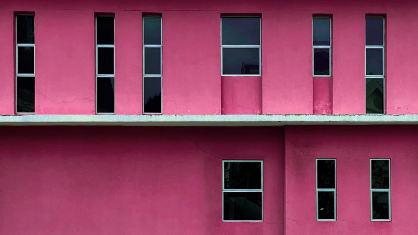 a pink building with a motorcycle on the side