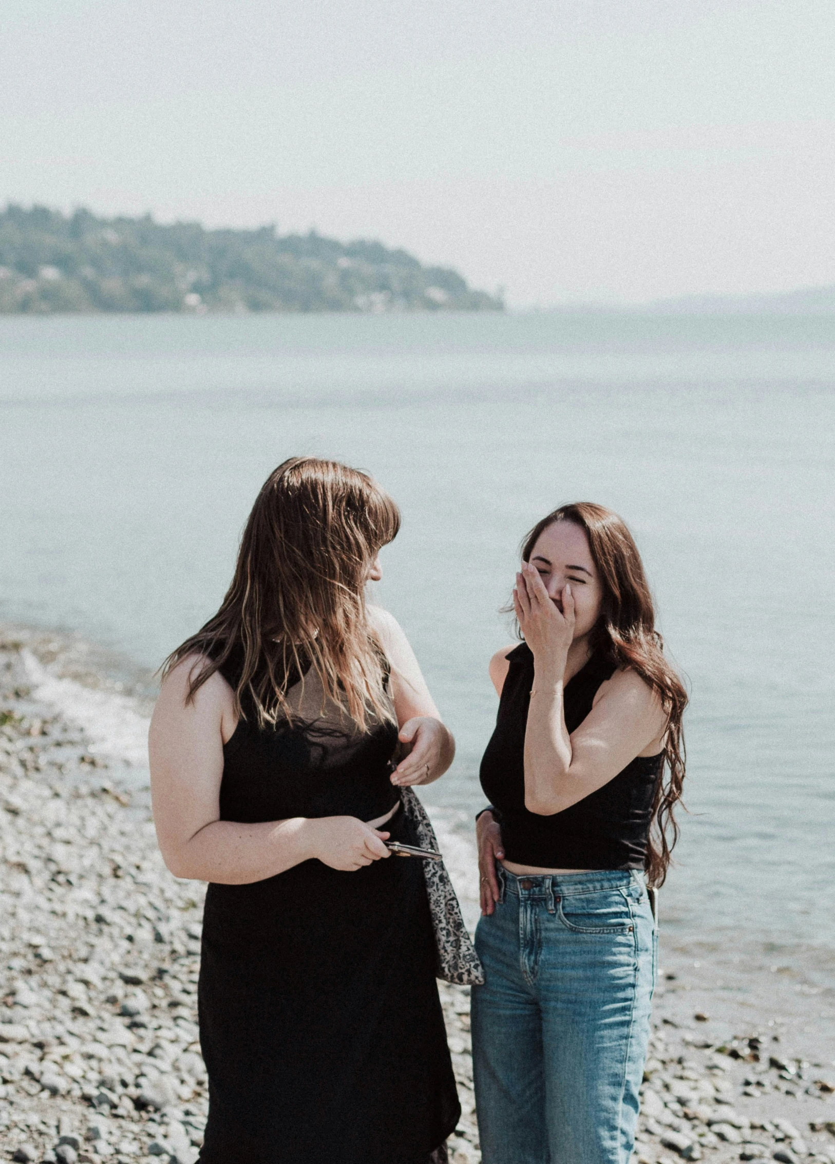 two women talk as they look out at the ocean