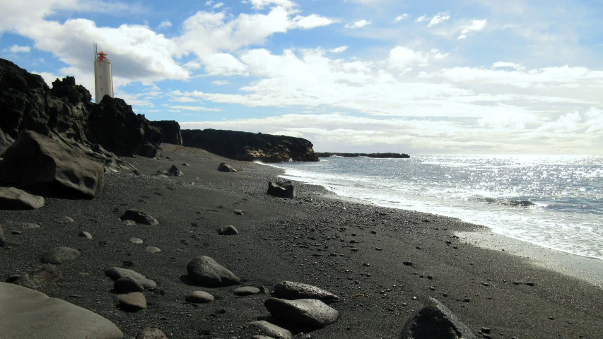 a sandy beach with lots of water and rocks