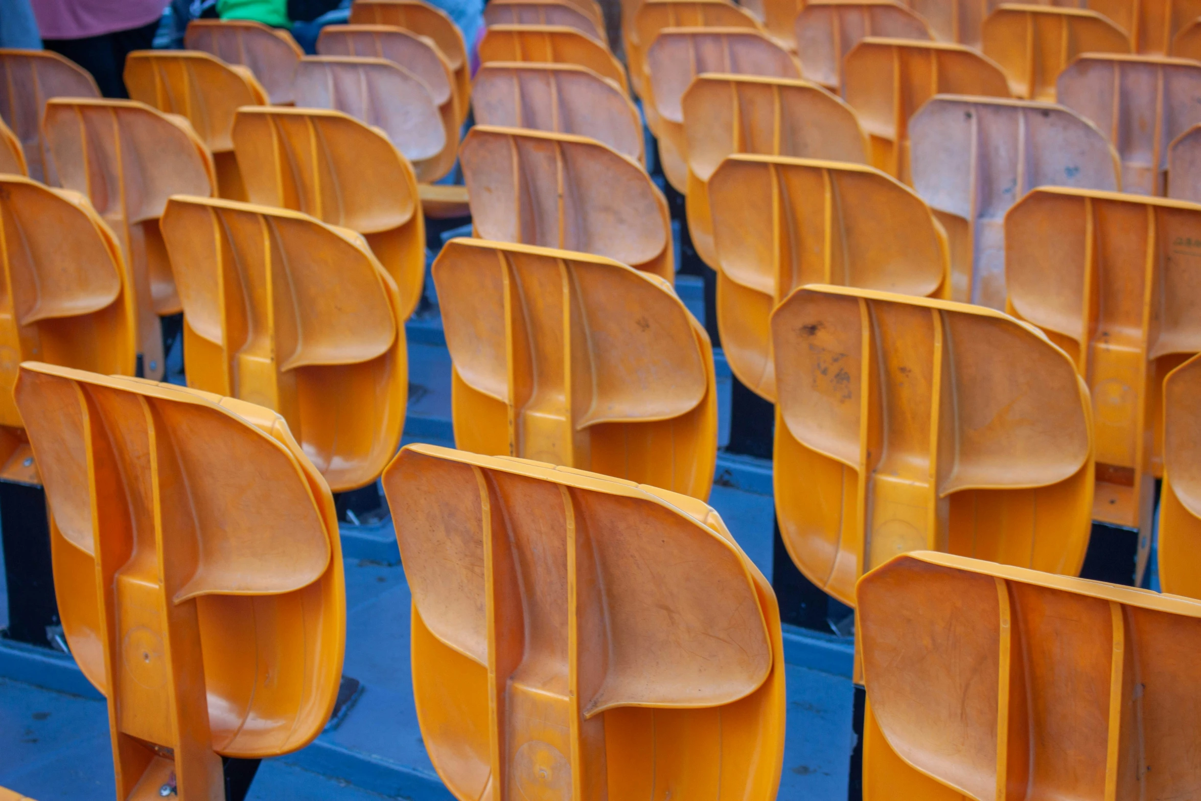 a row of chairs in a stadium with brown seats