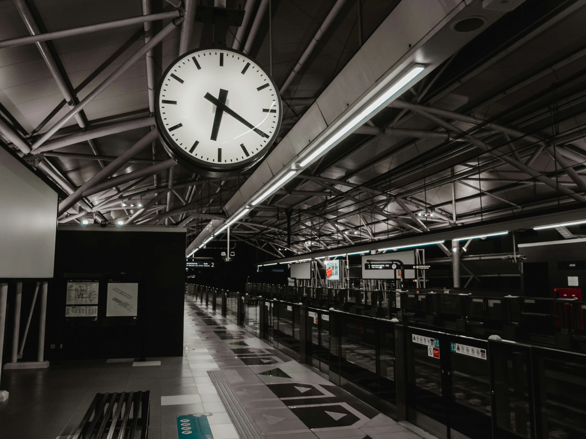 the clock hangs from the ceiling in the empty station